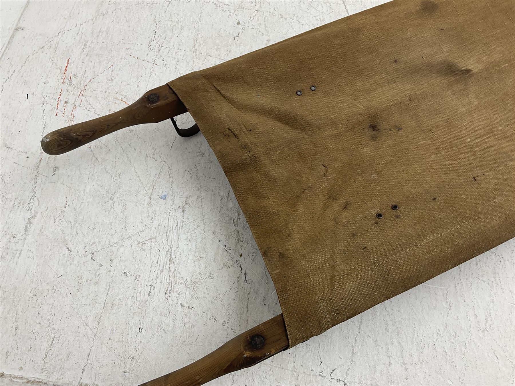 WW1 British casualty stretcher with iron mounted pitch pine sides and canvas base; stamped 'HL1917' and L7 with broad arrow in a triangle L236cm ( reputedly recovered from a barn at Bapaume on The Somme)