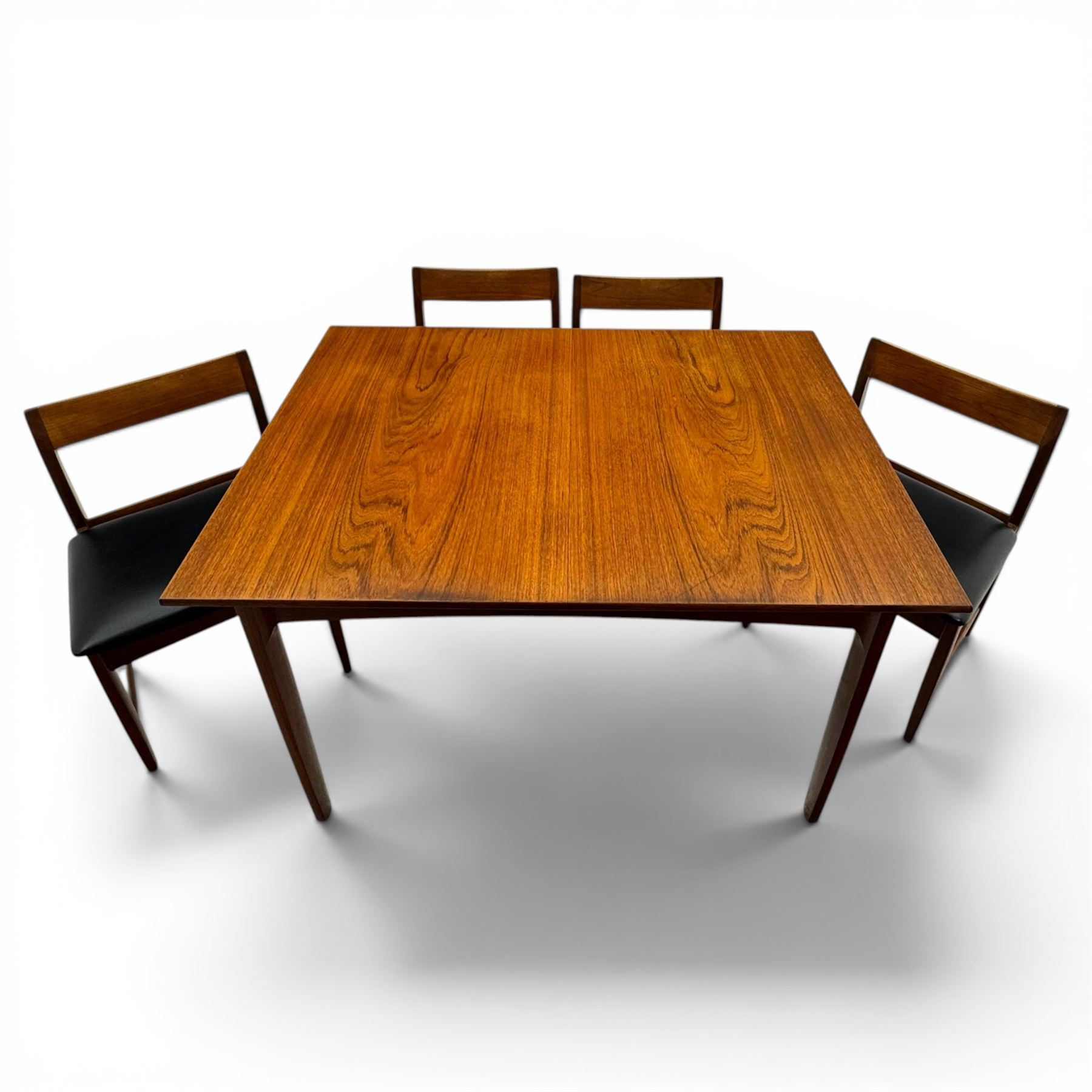 BCM (Bath Cabinet Makers) - mid-20th century teak extending dining table with BCM set of four teak dining chairs with bar back and black vinyl seats