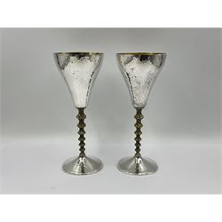 Pair of modern silver goblets by Stuart Devlin, the tapering cylindrical bowls each with spot hammered decoration and gilt interiors, the parcel gilt stems with signature textured detailing and six graduating knops, upon conforming spreading circular foot, hallmarked Stuart Devlin, London 1976, H17.7cm