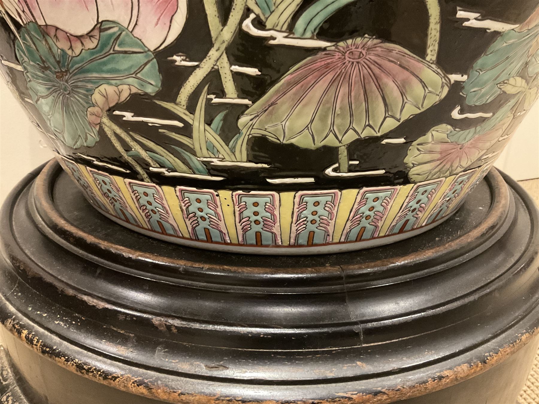 Large 20th century Chinese famille noir glazed porcelain jardinière, of ovoid form, the exterior enamelled with butterflies and white cranes amidst blossoming water lilies and pads against a black ground, between two stylised polychrome borders and beneath a key border to rim, the interior enamelled with red koi fish swimming amongst water fronds and weeds, with printed red character mark beneath, the whole upon an ebonised hardwood stand with three cabriole legs, jardinière H42cm D47cm, including stand overall H69.5cm