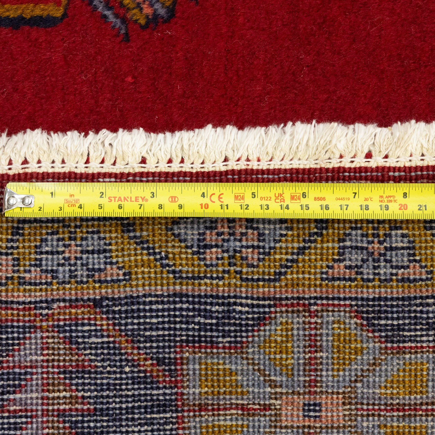 Turkish Anatolian hand-knotted carpet, red field centred by a large pale blue geometric medallion flanked by pink octagonal medallions, scattered stylised motifs, enclosed by multiple geometric borders
