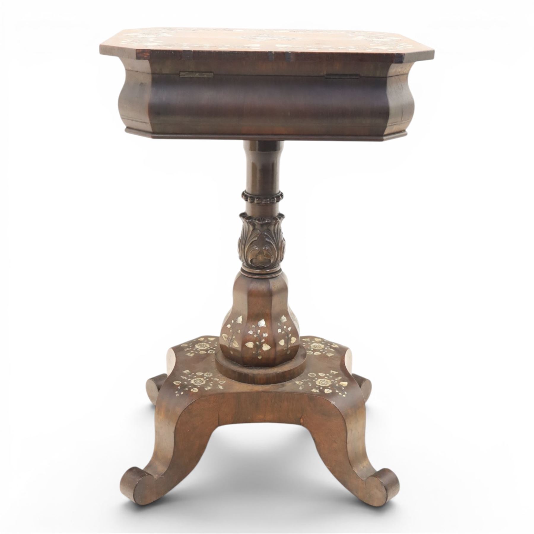 Victorian mahogany and mother-of-pearl inlaid work table, the octagonal hinged top enclosing a mirror and fitted compartmented interior, raised on a carved pedestal and quatriform platform base with scrolled feet