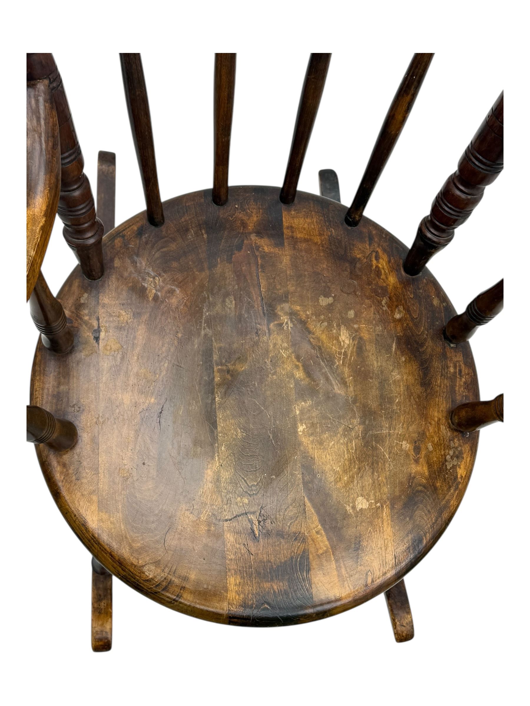 Late 19th century elm and beech Windsor rocking chair, with shaped top rail over turned spindles and curved arms, circular seat raised on turned legs united by stretcher on rockers