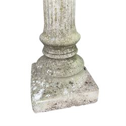 Weathered cast stone sundial on fluted pedestal