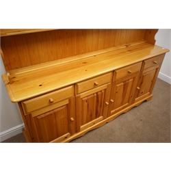  Pine farmhouse dresser, two tier plate rack above four drawers and cupboards, shaped plinth base, W193cm, H203cm, D43cm  