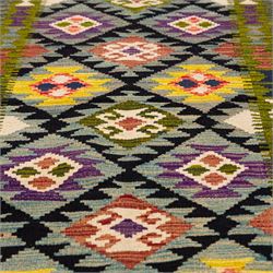 Afghan Maimana flatweave kilim, central field features large bold nested diamond motifs and stylized geometric lozenge patterns on olive purple, blue, and green tone ground, border stripe in blue tones, with fringe