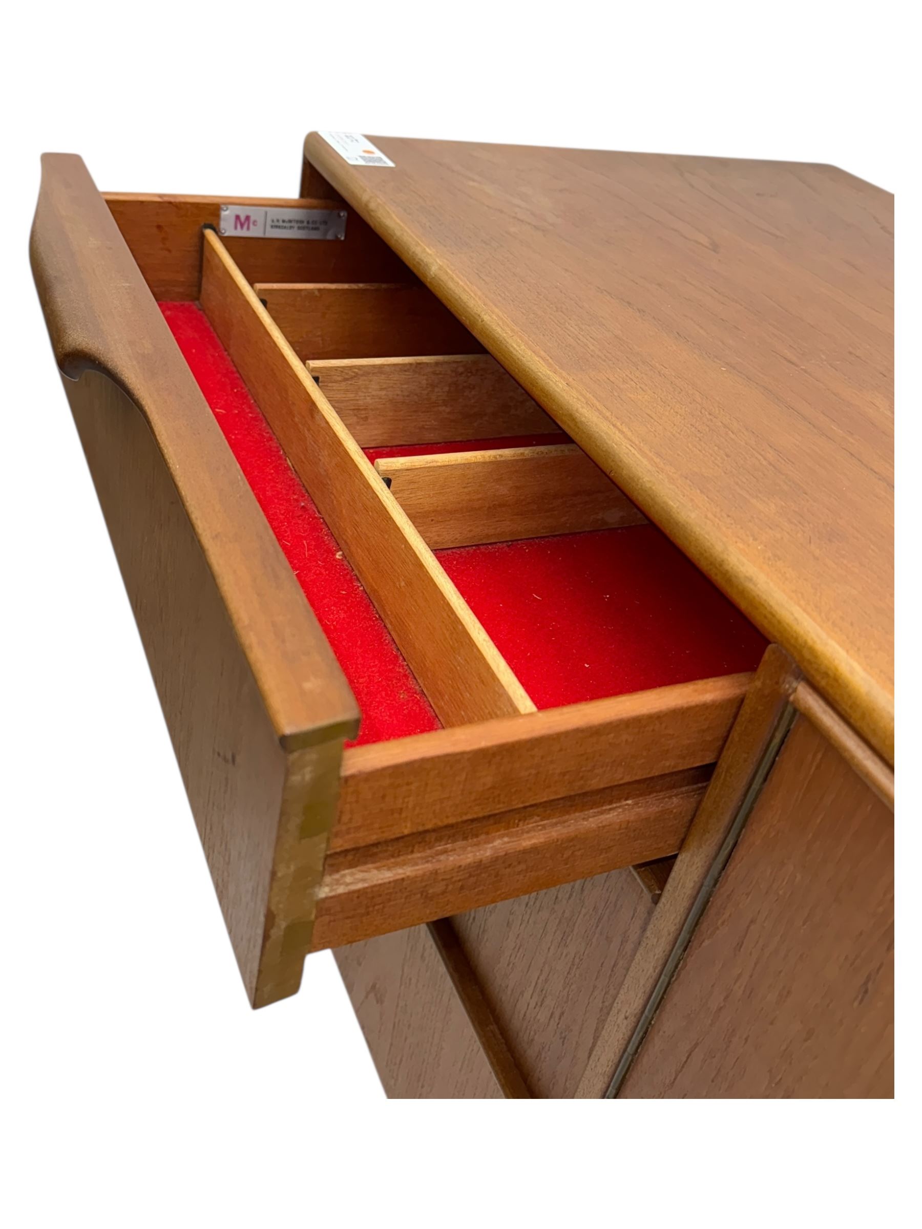 Tom Robertson for AH McIntosh & Co of Kirkaldy - mid-20th century teak 'Dunvegan' sideboard, with three graduating drawers fitted cutlery divider, three cupboards one fall front each with recessed sculptural handles, raised on shaped and tapering supports