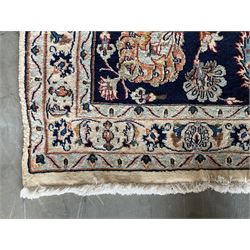 Large Persian Heriz carpet, ivory ground with trailing floral design and decorated with stylised flower heads, matching design to blue ground boarder, multiple guards with foliate decoration 
