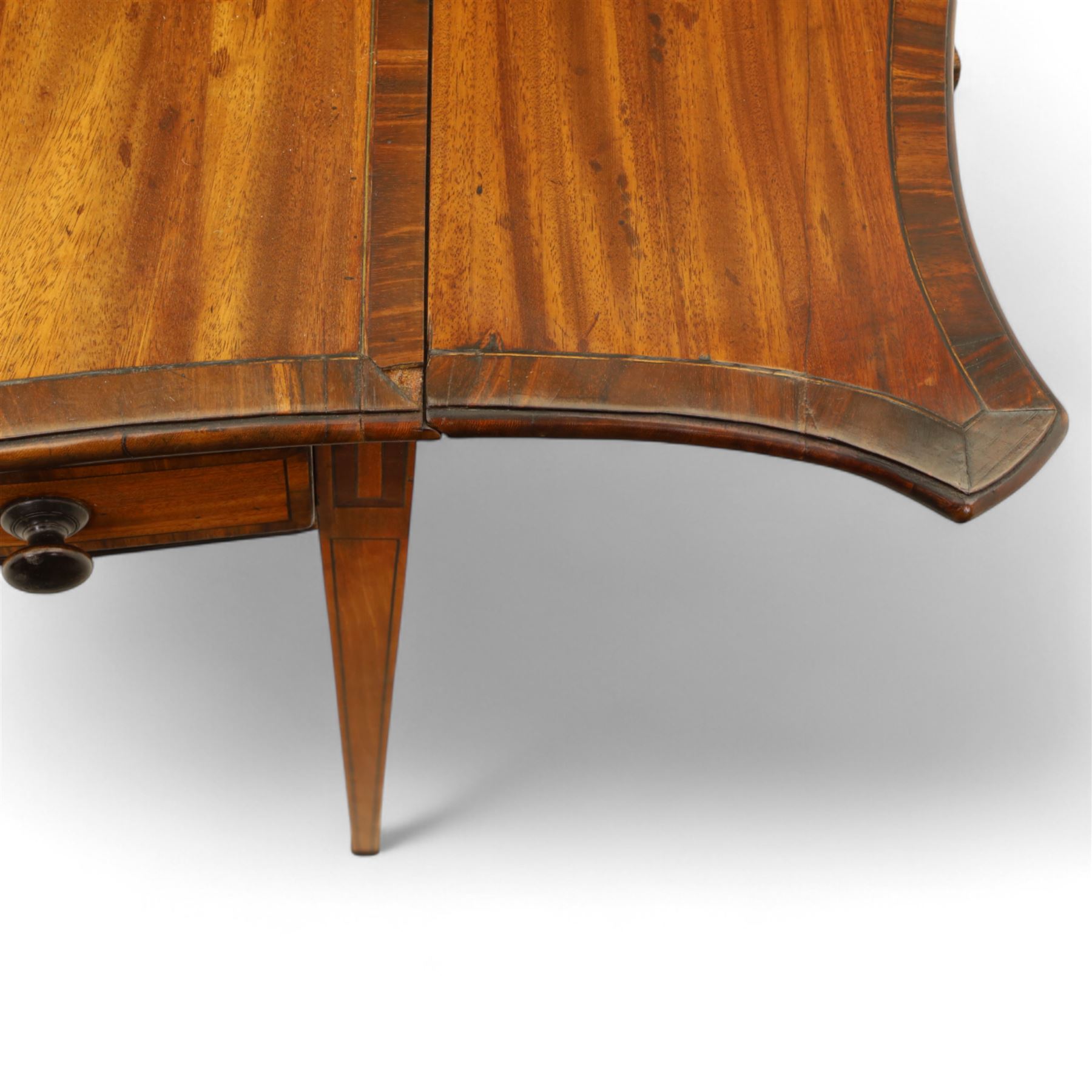 Goergian small butterfly pembroke table, the rectangular top with crossbanded edge and rounded drop leaves, single frieze drawer with opposing dummy drawer, raised on square tapering legs with stringing, terminating in brass castors