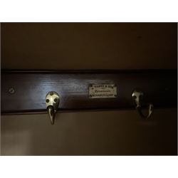 Edwardian walnut combination breakfront triple wardrobe, projecting cornice over cushioned and fluted frieze, central fielded panelled cupboard carved with foliate decoration above two short and three long drawers, flanked by two bevelled mirror doors enclosing hanging hooks with single drawers to base, retailed by J Tonks & Sons, Scarborough