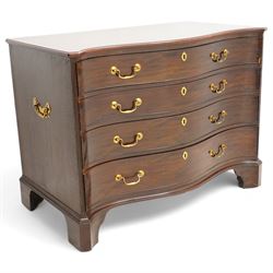 George III mahogany serpentine chest, moulded top over four cock-beaded drawers, the top drawer fitted with baize lined slide opening to reveal divisions,  enclosed by canted and fluted upright corners, the drawer fronts fitted with brass swan neck handles and circular plates with oval escutcheons, lower moulded edge over bracket feet, on lignum vitae castors
