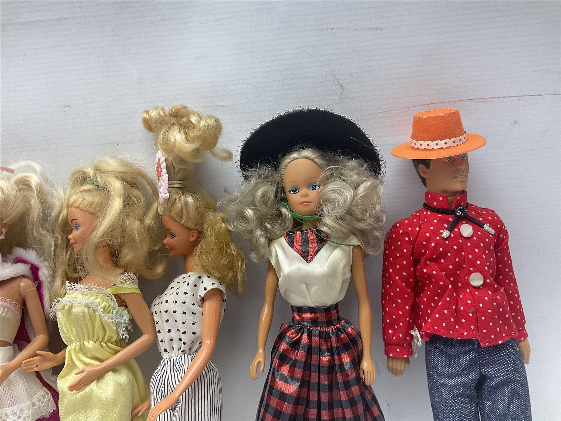 Eleven 1980s fashion dolls, predominantly Barbie/Ken, all dressed; together with some additional clothing.