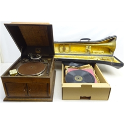  'His Masters Voice' model 103 gramophone in oak fitted case, collection of records and a brass trombone marked 'made for Brratts of Manchester', cased  