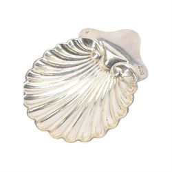 Edwardian silver shell butter dish, upon three bun feet, together with a matching shell spoon engraved with initial, both hallmarked Josiah Williams & Co, London 1906 and 1914, together with an Edwardian milk jug, open sucrier and sugar tongs, the jug and bowl of circular part fluted form with bead rim, hallmarked Mappin & Webb Ltd, Sheffield 1902, both sets contained within fitted tooled leather boxes with silk and velvet lined interiors