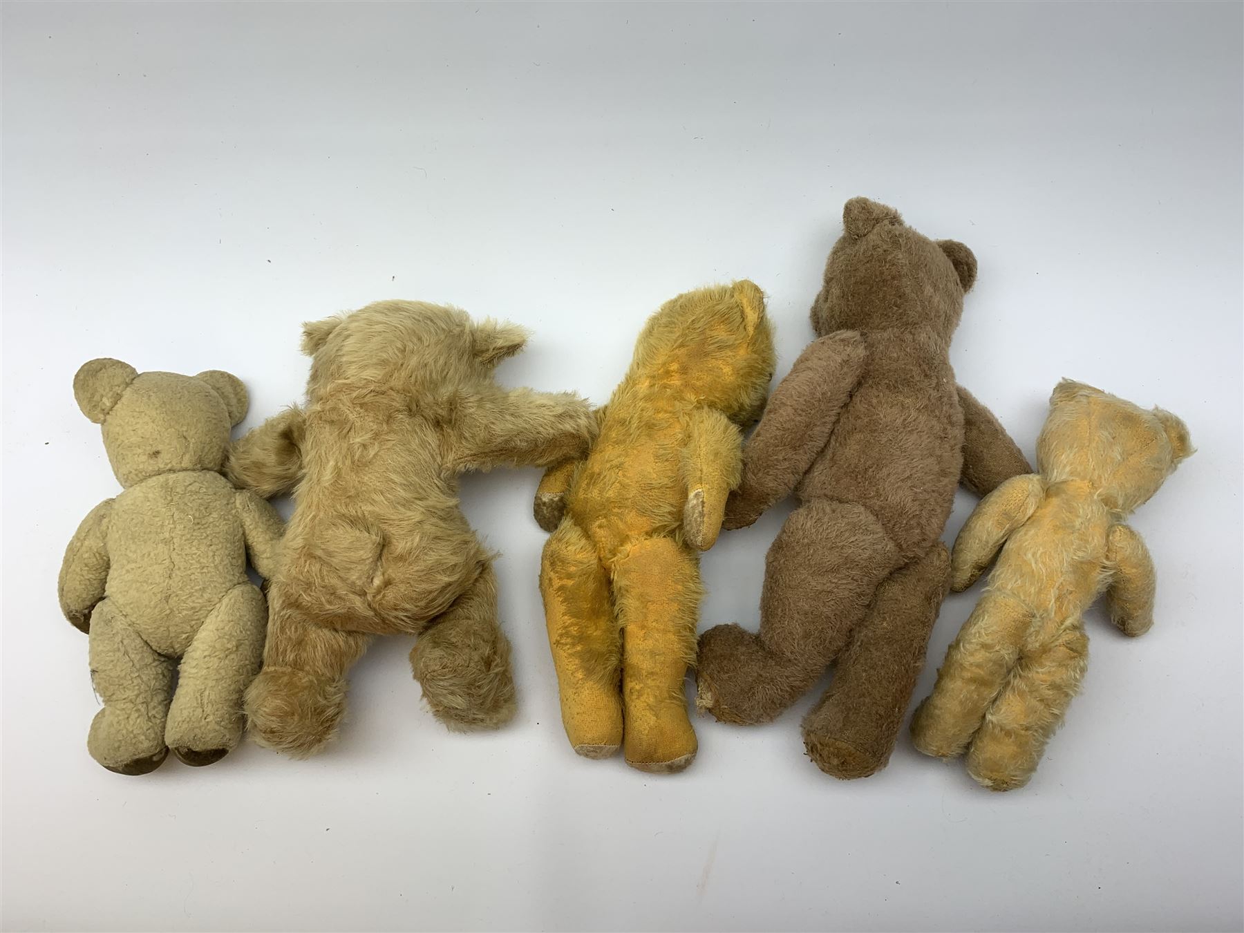 Nine English teddy bears 1950s-60s including wood wool filled Pedigree bear with swivel jointed head, glass eyes, vertically stitched nose and mouth and jointed limbs H14.5