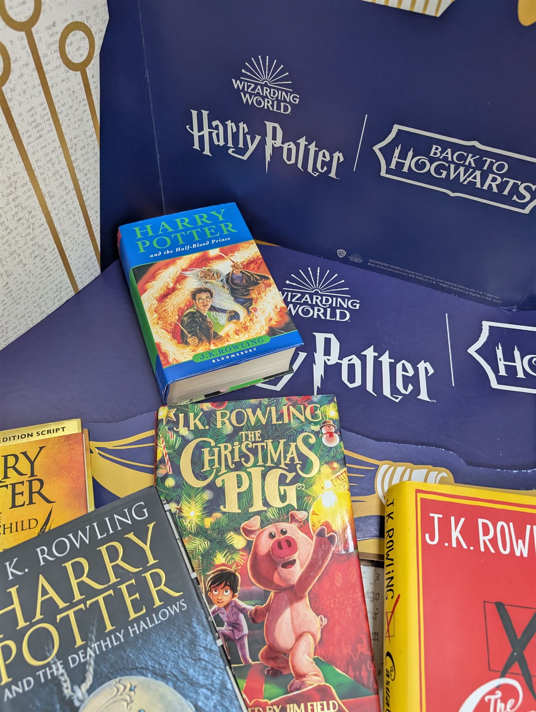 Eleven JK Rowling books, comprising six Harry Potter books, including four first editions, Fantastic Beasts screen play, Harry Potter and the Cursed Child, Tales of Beedle the Bard, Casual Vacancy first edition, Christmas Pig First edition and a Harry Potter card board back drop