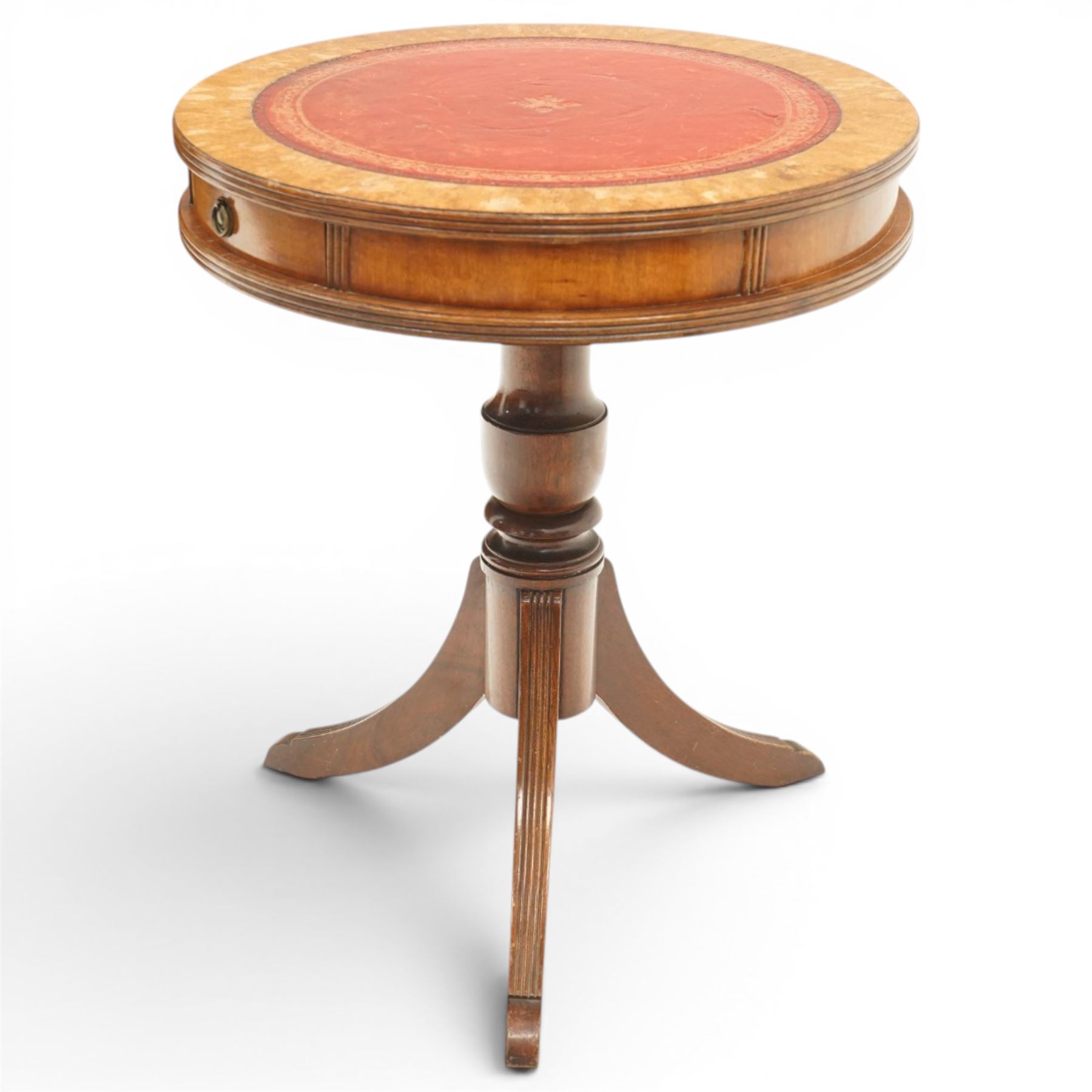 Regency style mahogany drum table, circular red leather inset top with gilt and blind tooling, bird's-eye maple crossbanded border, fitted with two opposing pull-out slides, on turned pedestal and three outswept support