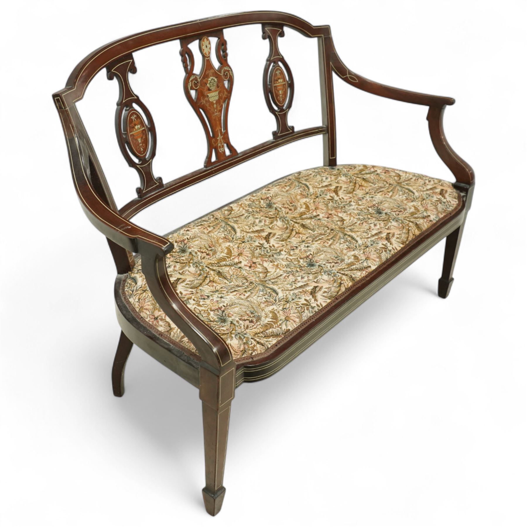 Edwardian marquetry inlaid mahogany salon settee, with bowed top rail and pierced splat back featuring central classical urn flanked by oval floral medallions, floral upholstered seat on boxwood strung square tapering legs terminating in spade feet