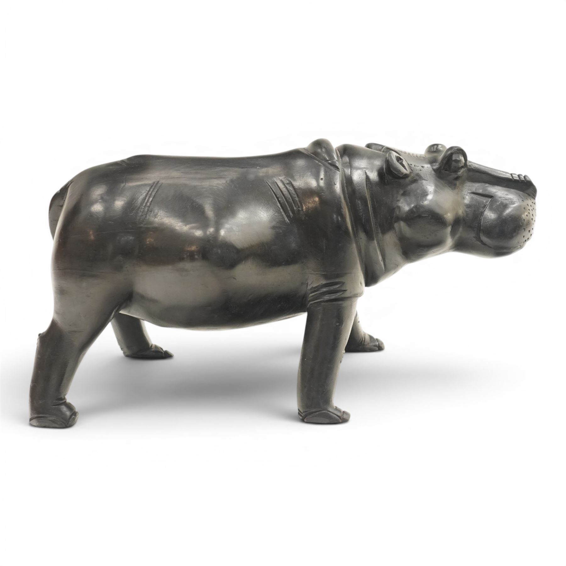 African carved hardwood ebonised figures of a rhinoceros and hippopotamus, each with stylised incised detail and polished dark finish, largest H 61cm, W 91cm)