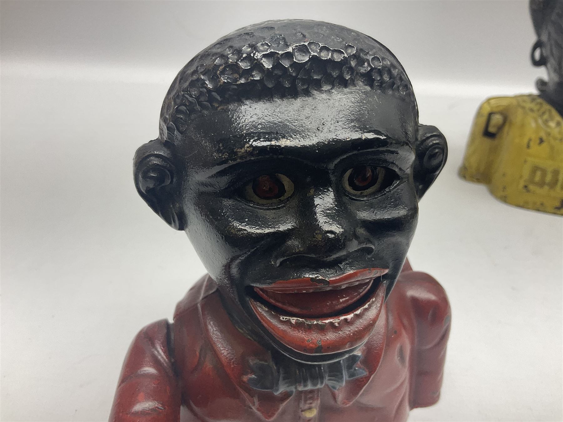 Three early 20th century cast-iron mechanical money banks as a family group comprising mother 'Dinah' patented 1911, father 'Jolly Man' patented 1902 and son 'Little Joe' patented 1910 by John Harper & Co; all with the same hand-to-mouth action; parents H16cm (3)