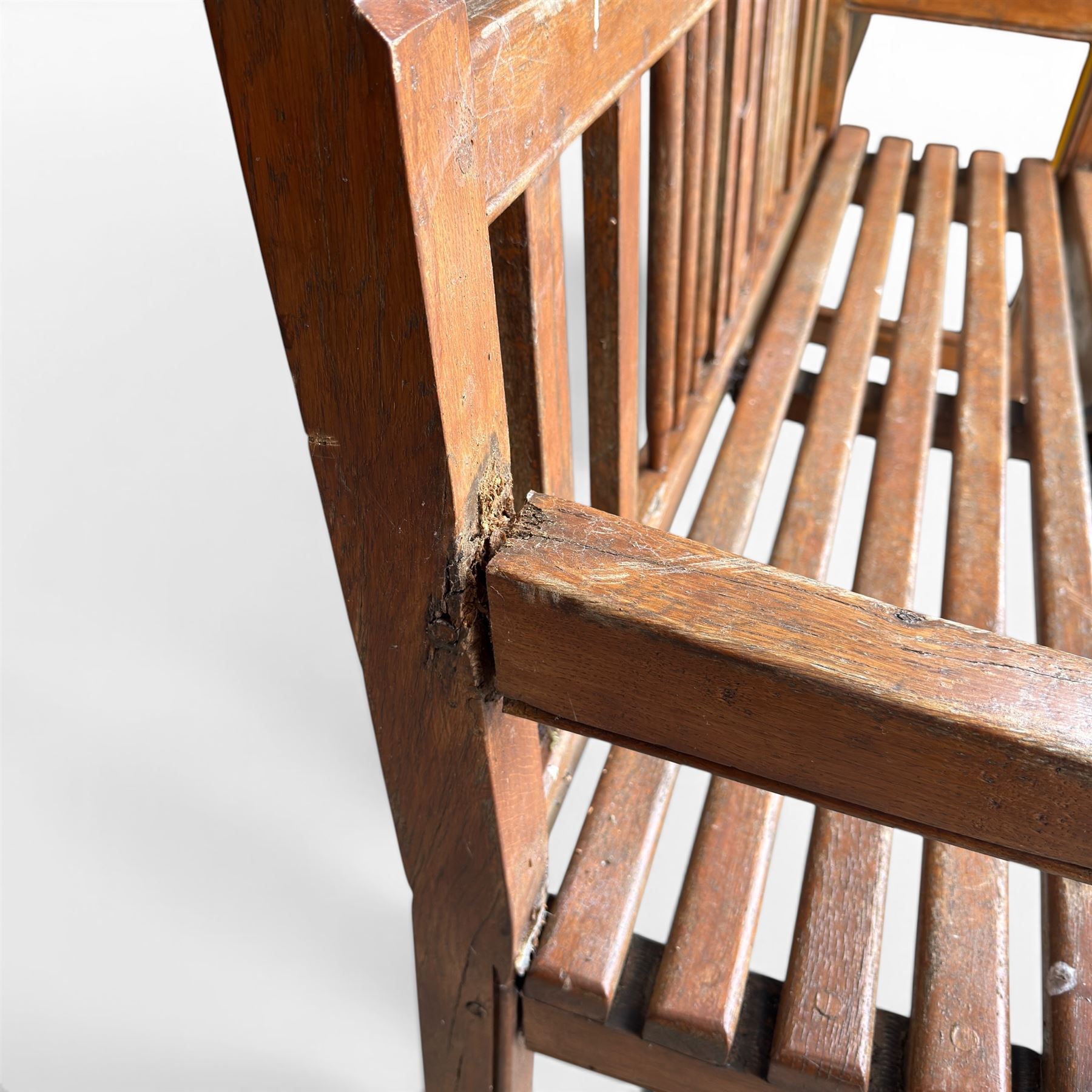 20th century teak cricket bench featuring a central splat with moulded cricket bat and ball motif flanked by stylised wicket spindles, over a slatted seat and square supports