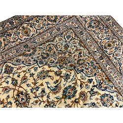 Persian Kashan golden ivory ground carpet, the central medallion surrounded by a field of interlacing branch and stylised plant motifs, the guarded border with scrolling design decorated with flower heads 