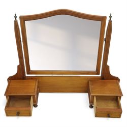 Two early 20th century mahogany swing dressing mirrors, comprising one with arched rectangular plate in a moulded frame on shaped supports, flanked by two inlaid trinket drawers (H 69cm, W 88cm, D 20cm), together with another rectangular plate mirror on turned supports upon bun feet (H 58cm, W 48cm, D 23cm)