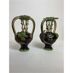 Pair of 19th century Portuguese Palissy style Majolica puzzle jugs, attributed to Manuel Mafra, with mossy rim and pierced lattice neck, twin handles in the form of snakes and the body decorated with frogs, lizards, and moths on a mottled brown glazed ground, unmarked, H20cm