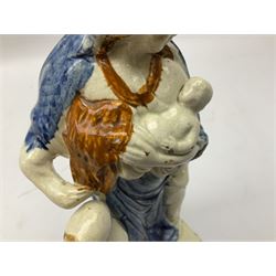 Late 18th century Prattware figure representing Charity, modelled as a mother with baby in her arms and two small children clutching at her robes, upon a square base, overall H21cm.