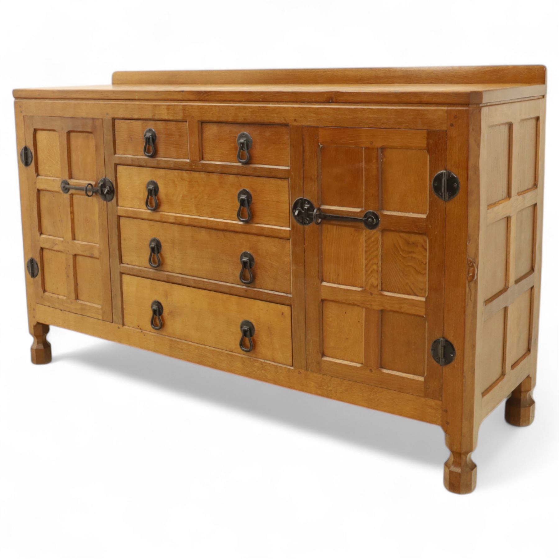 Mouseman - oak sideboard with adzed top and raised gallery back, over two short drawers and three long drawers, flanked by panelled cupboard doors with wrought iron fittings, on octagonal feet, carved with the signature mouse to the right-hand door