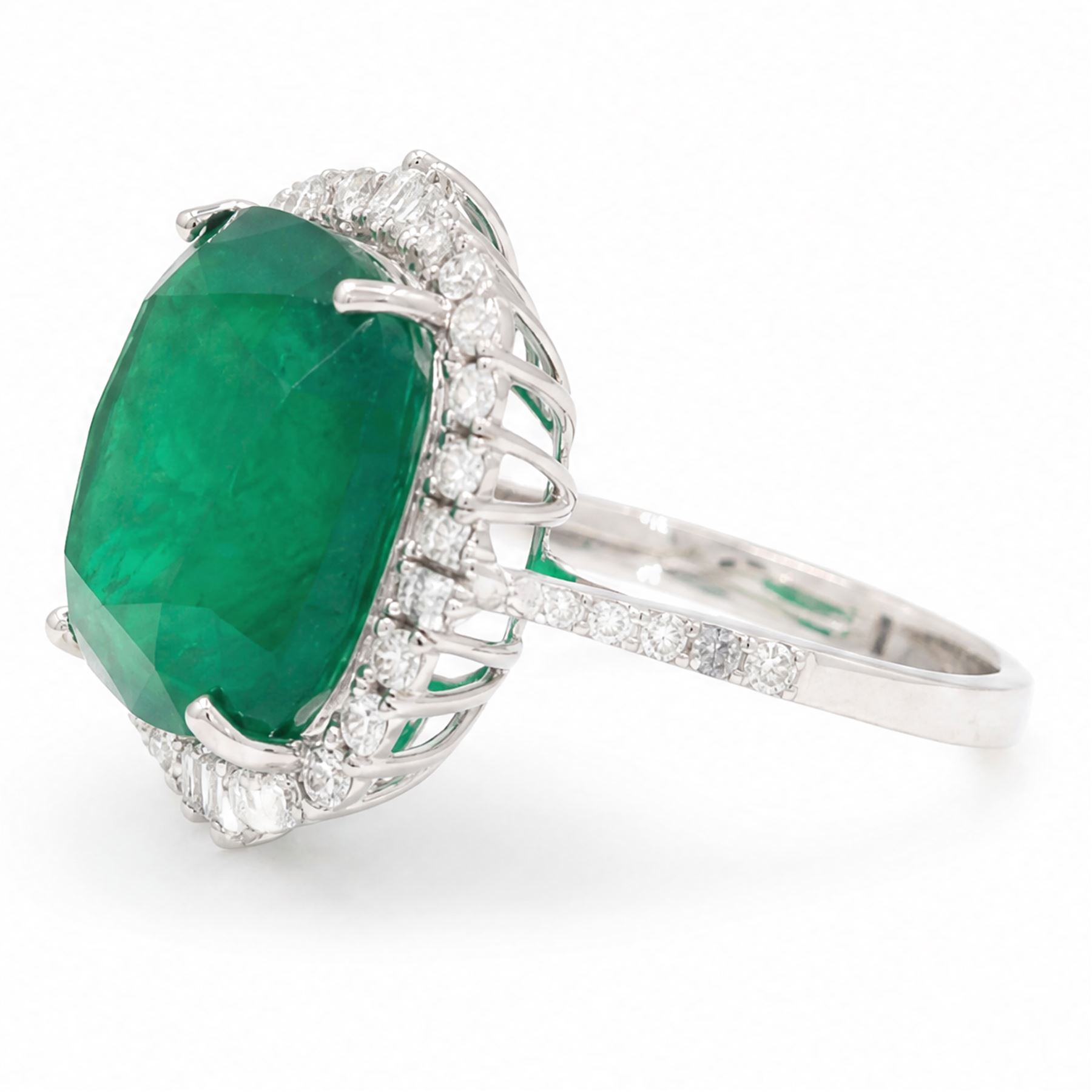 18ct white gold emerald and diamond cluster ring, single cushion cut emerald of approx 13.20 carat, surrounded by round brilliant and baguette cut diamonds and diamond set shoulders, stamped 18K, total diamond weight approx 1.00 carat