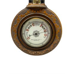 An Edwardian hall barometer with a compensated Aneroid movement by the German maker Julius Gischard, porcelain four-and-a-half-inch register measuring barometric air pressure from twenty-six to thirty-one point nine inches, weather predictions written in upper and lower case gothic script with initial letters highlighted in red, blue steel indicating hand and brass recording hand, dial bezel with flat bevelled glass, spirit thermometer recording temperature in degrees Fahrenheit and Celsius on an unglazed opal plate with arched crest above, Dial inscribed “Wooley & Sons Manchester”.
H46cm    


