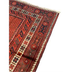 Persian Kelardasht red ground rug, the field decorated with two geometric medallions, multi-band border decorated with stylised flower heads and geometric repeating patterns