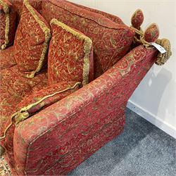 Large Knole design hardwood-framed three-seat drop-arm sofa, upholstered in crimson fabric decorated with trailing acanthus leaves and shields, together with scatter cushions 