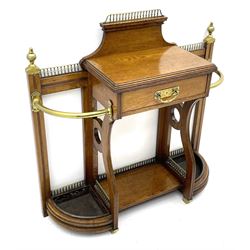 Late Victorian oak umbrella and stick hall-stand, the top fitted with brass balustrade and finials, central drawer flanked by curved ends each with curved brass bars and metal drip trays, central undertier 