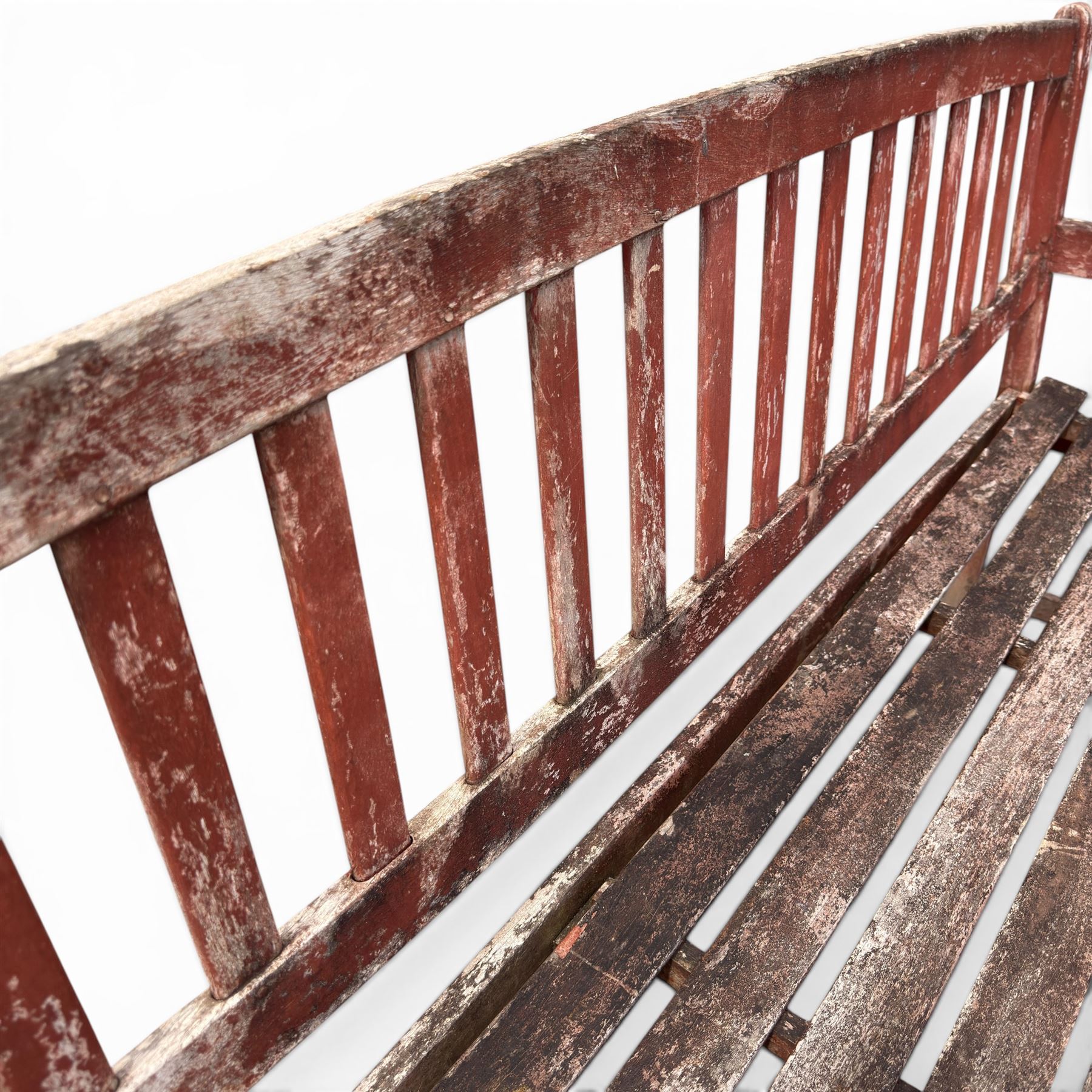 Teak garden bench, with slatted seat and spindle back, shaped armrests, finished in weathered red painted finish.