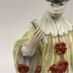 18th century Meissen figure of a Avvocato or the Lawyer from the Commedia Dell'arte series, circa 1740-45, modelled by J J Kandler, wearing gilt edged black tricorn hat, white mask, and yellow cape adorned with red rosettes, holding a scroll in his right hand, upon shaped oval base, no visible mark, H14.5cm