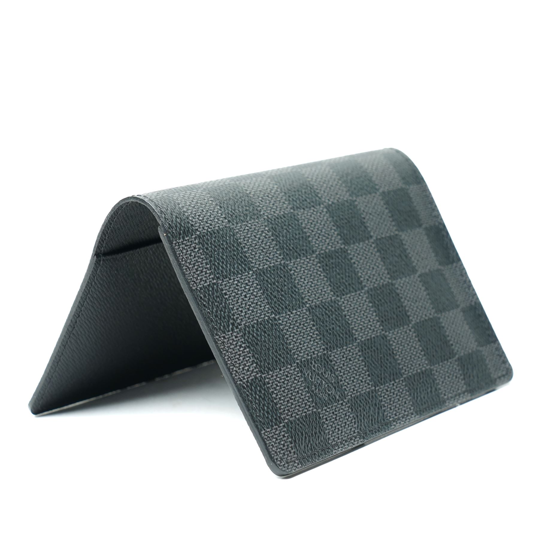 Louis Vuitton Damier Graphite canvas passport holder, the black and grey checkerboard exterior opening to a crossgrain leather interior with card slots and slip pockets, stamped Louis Vuitton Paris and made in Spain, together with original Louis Vuitton box and dust cloth