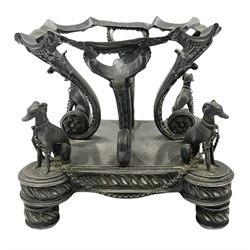 Pewter centrepiece stand, possibly John Round & Son of Sheffield, figured with four hounds linked by chains to their collars surrounding four scrolled branches with floral terminals supporting the raised stand, upon gadrooned base and feet, stamped 'JR & S S' beneath