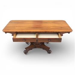 Victorian rosewood library table, rounded rectangular top with two frieze drawers with turned wooden knobs, quatriform base with scrolled ends terminating in brass castors  
