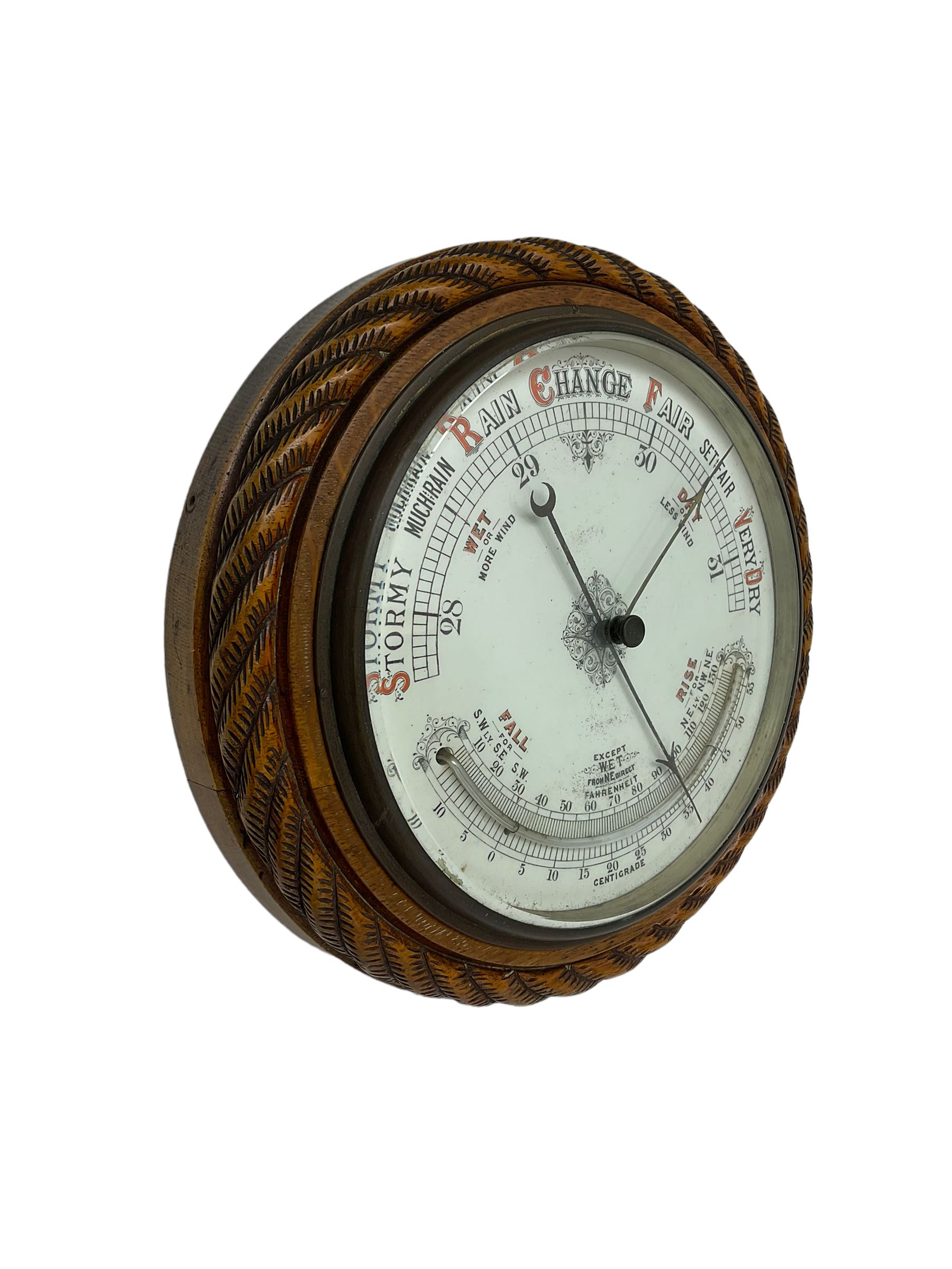 1930’s aneroid barometer with a 10” porcelain dial recording barometric air pressure from 28 to 31 inches with weather predictions, curved mercury thermometer, steel indicating hand and brass recording hand, oak case with carved rope work decoration.