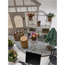 1:12 scale dolls house conservatory and garden accessories, including white wooden glazed conservatory on a stone effect base, black and white metal garden seating, barbecue, plant shelves, parasol, barbeque accessories, large planters, rabbit hutch, animals, chimenea, etc