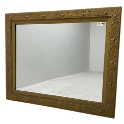 Rectangular gilt framed wall mirror, decorated with trailing leafy branches and flowers heads, plain mirror plate