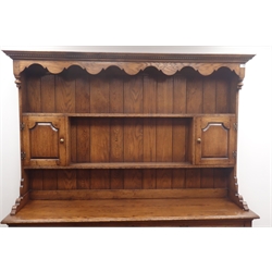  17th century style medium oak dresser, projecting cornice, dentil frieze, two plate shelves with two cupboards above four drawers and four cupboards, stile supports, W181cm, H198cm, D49cm  