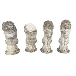 Four weathered cast stone lions in seated poses