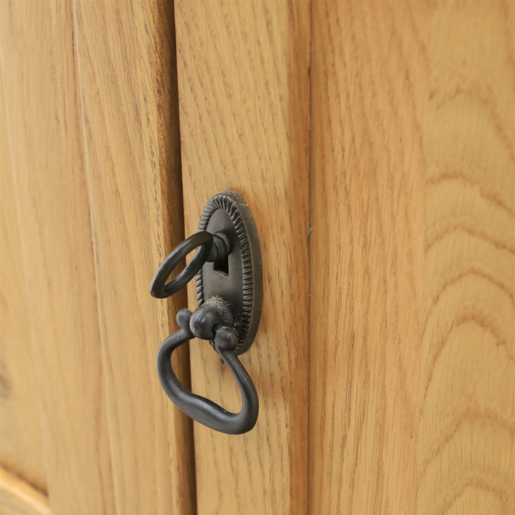 Contemporary oak sideboard, with rectangular top above three drawers and three cupboard doors, blackened metal handles, raised on stile supports