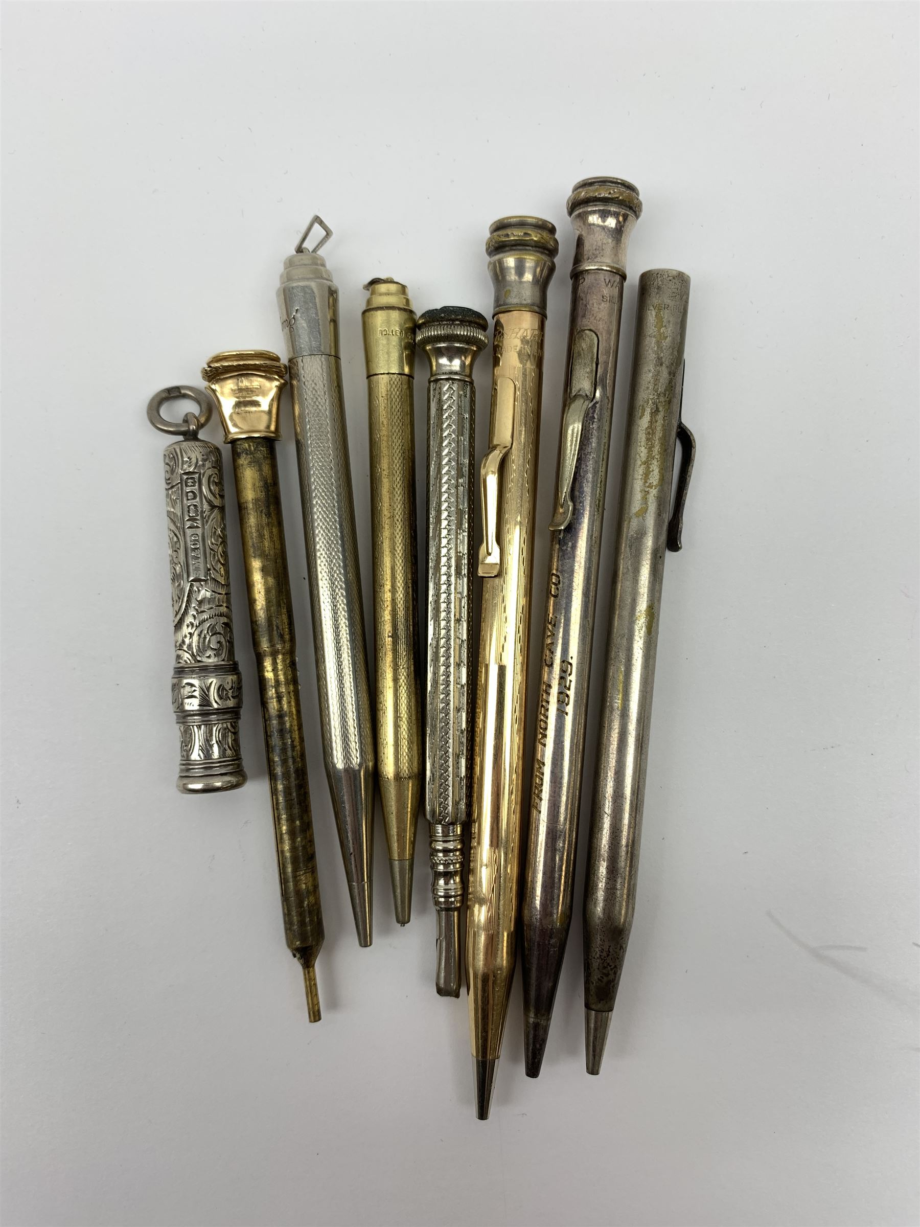 A late Victorian Sampson Mordan & Co silver push action propelling pencil, with foliate engraved decoration and suspension ring terminal, hallmarked Sampson Mordan & Co, London 1896, together with a group of vintage pens including examples by Eversharp, a number marked Silver Plated, Rolled Gold, and Gold Filled. 