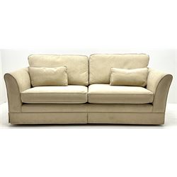 Large three seat sofa upholstered in cream fabric, castors 