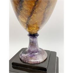 Early 19th century and later Blue John urn, Winnats one vein, of ovoid form with integrated cover and ball finial, upon a spreading circular base, and square stepped black lacquered base, H34.5cm