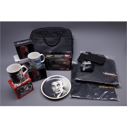 Quantity of James Bond memorabilia and promotional items including two polo shirts embroidered Goldeneye and Tomorrow Never Dies, laptop case, Skyfall Compact Poker Set, six ceramic mugs (four boxed), sock and keyring set etc  